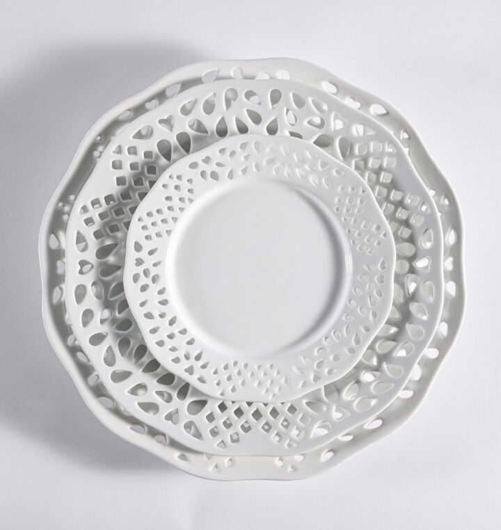 Lattice dinnerware collection featuring an elegant white porcelain design with intricate cutout detailing along the rim. Includes Salad / Dessert Plate (7.25"), Bowl (8"), Dinner Plate (10.25"), and Demitasse Cup & Saucer. Perfect for sophisticated tablescapes and refined event presentations.