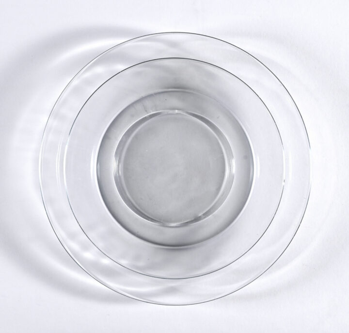 Swedish Modern china collection featuring minimalist clear glass plates with sleek, contemporary lines. Includes Bread & Butter Plate (6"), Salad Plate (8"), and Dinner Plate (10"). Perfect for modern tablescapes and elegant event settings.