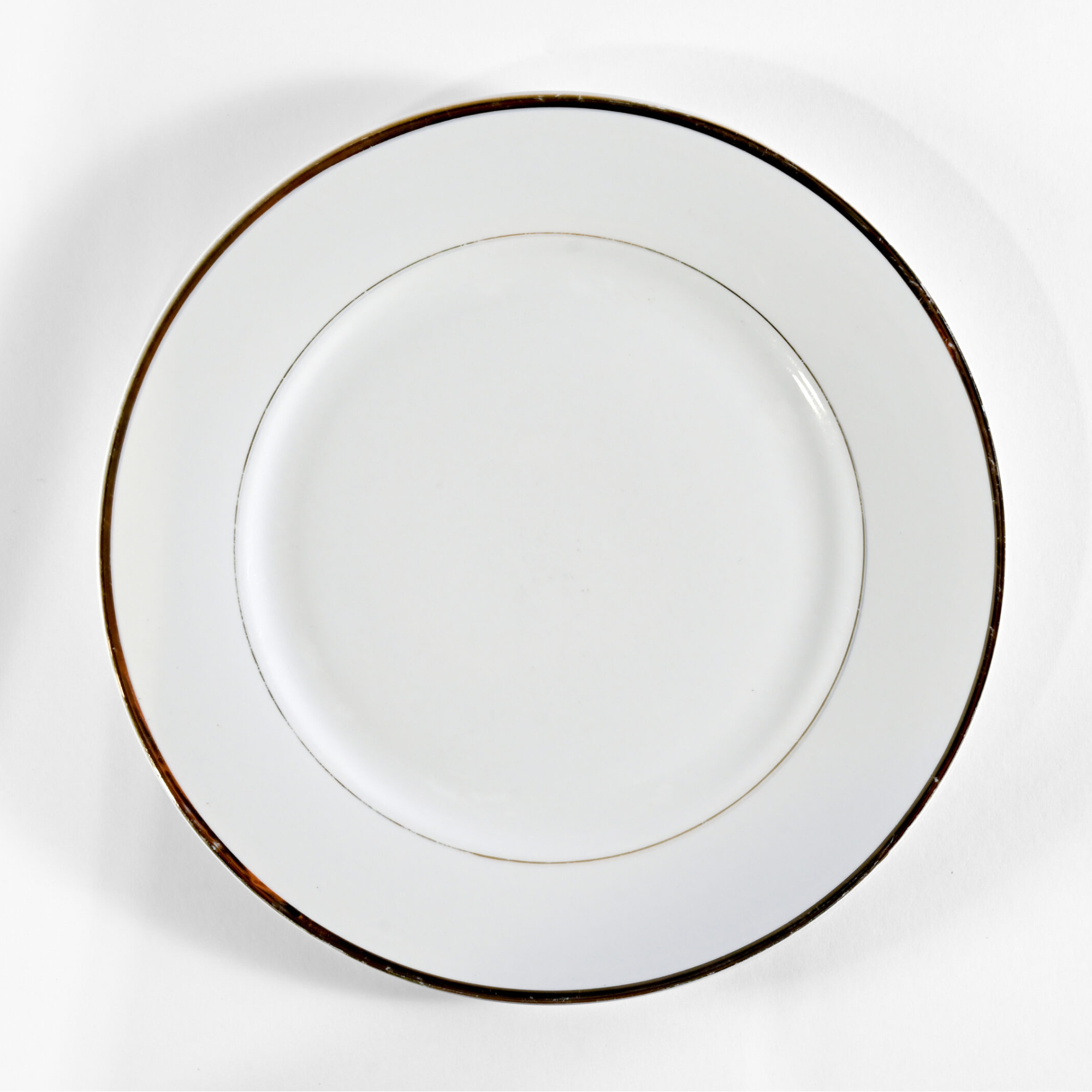 Gold Band Charger Plate, 12-inch — elegant white porcelain charger with a refined metallic gold rim. Perfect for formal dining settings, weddings, and upscale events to add a sophisticated finishing touch to any table design.