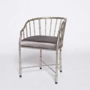 Golden bamboo-style armchair with a metallic faux bamboo frame and open barrel-back design.