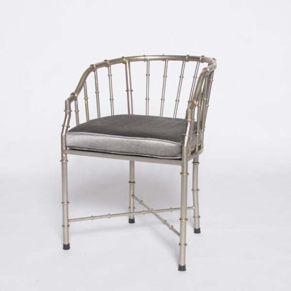 Golden bamboo-style armchair with a metallic faux bamboo frame and open barrel-back design.