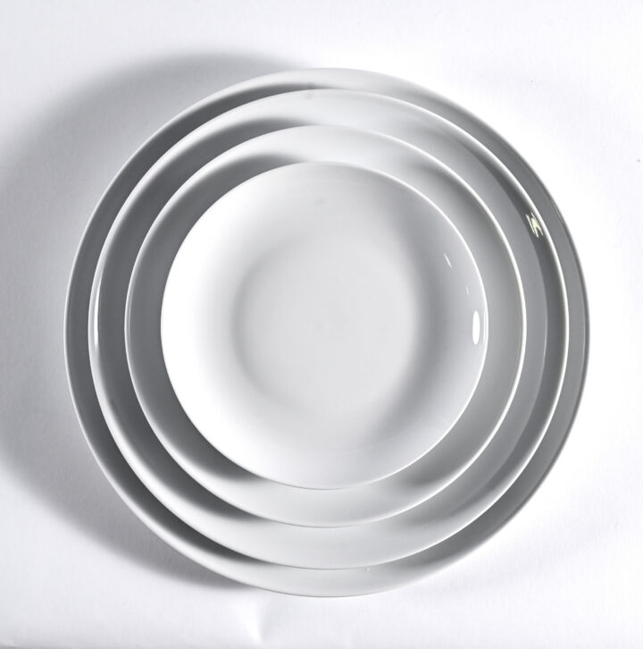 Coupe White dinnerware collection featuring a clean, minimalist design with smooth round edges in glossy white porcelain. Available in Bread & Butter Plate (6.75"), Salad/Dessert Plate (8.25"), Luncheon Plate (9.25"), and Dinner Plate (10.5").