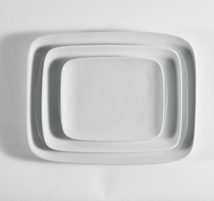 Coupe Rectangle China Collection featuring a sleek, modern white porcelain design with softly curved rectangular edges. Includes Bread & Butter Plate (6.5" x 5.25"), Salad Plate (8.75" x 6.75"), and Dinner Plate (10.75" x 8.25"). Ideal for contemporary dining and elegant event presentations.