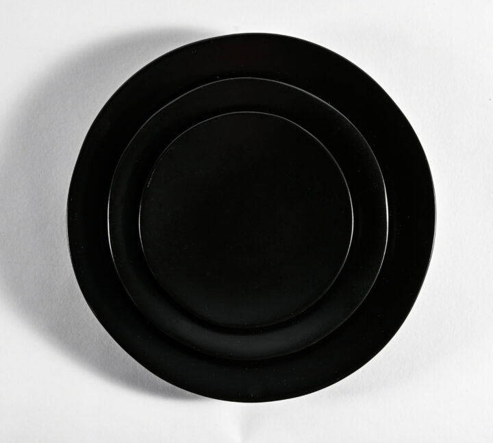 Heirloom Charcoal plate collection featuring a smooth matte black finish with organic, handcrafted edges. Available in 6.25-inch bread & butter plate, 8-inch salad plate, and 10.75-inch dinner plate sizes — perfect for modern and moody table settings.
