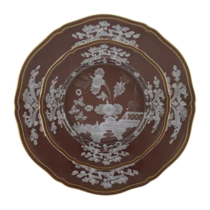 Ginori Oriente Italiano Castagna Plate featuring a rich chestnut brown base adorned with intricate white floral and landscape motifs, finished with a fine gold rim and scalloped edge — an elegant Italian porcelain design.