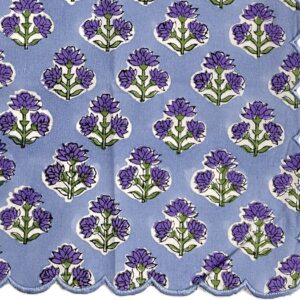 Scalloped dinner napkin in purple and green with a repeating floral design and coordinating scalloped trim.