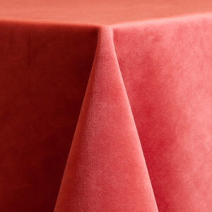 Coral velvet 132-inch round table linen featuring a plush texture and warm, pink-orange tone.