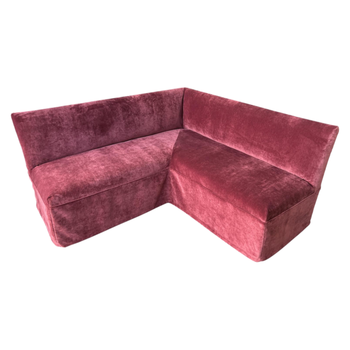 L-shaped banquette upholstered in rich Beaujolais velvet with tailored slipcover, modern modular lounge seating for events.