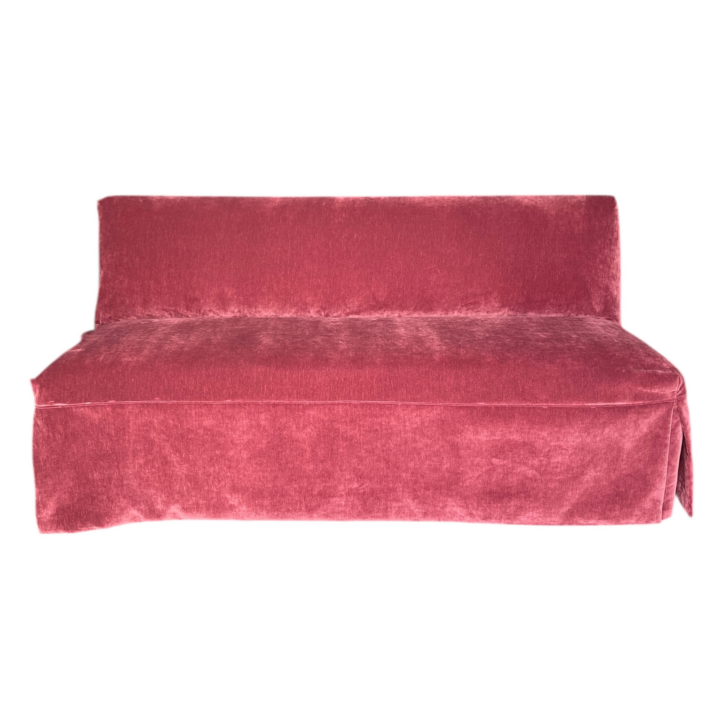 Straight banquette upholstered in Beaujolais velvet with a tailored slipcover, modern lounge seating for event setups.