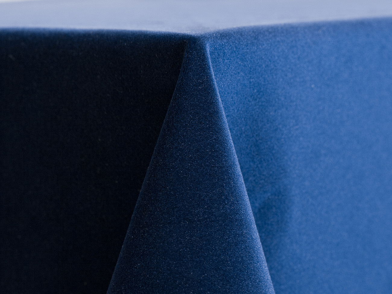 Marine blue velvet linen with a rich, soft texture and deep navy-blue tone draped over a table edge.